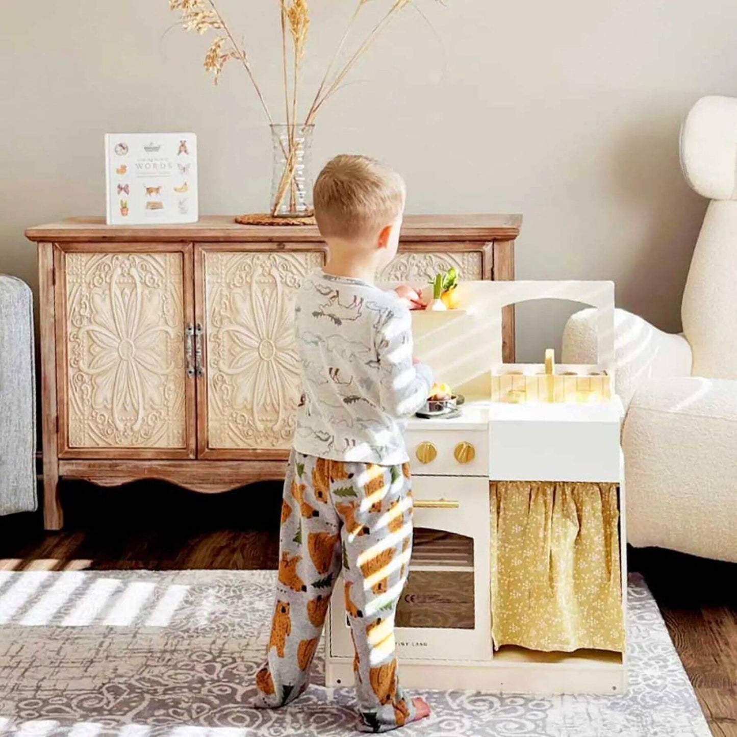Child playing with Tiny Land® Honey Kitchenette - Little Chef's First Kitchen in a living room.