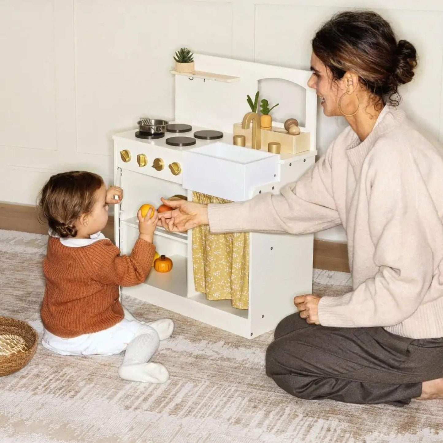 Woman and child playing with Tiny Land® Honey Kitchenette - Little Chef's First Kitchen on a carpeted floor.