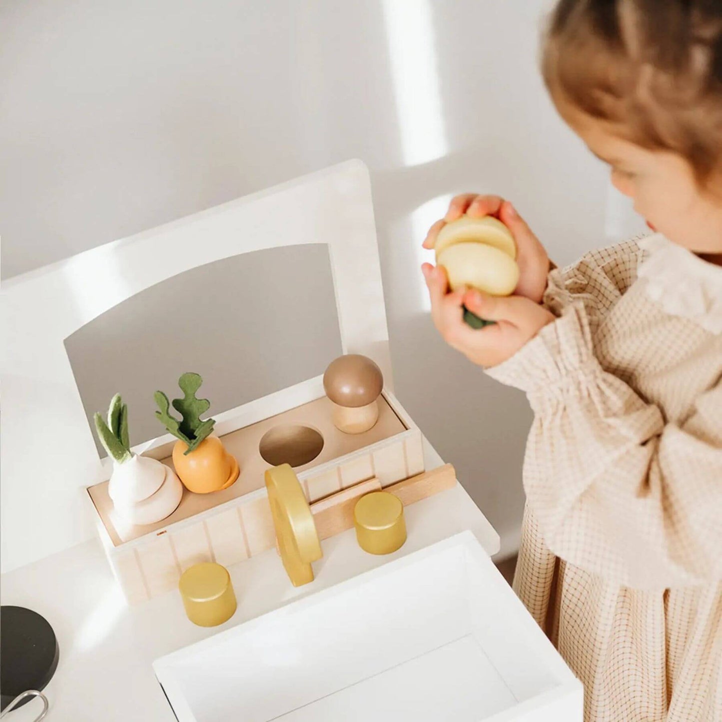 Child playing with Tiny Land® Honey Kitchenette - Little Chef's First Kitchen on a white surface