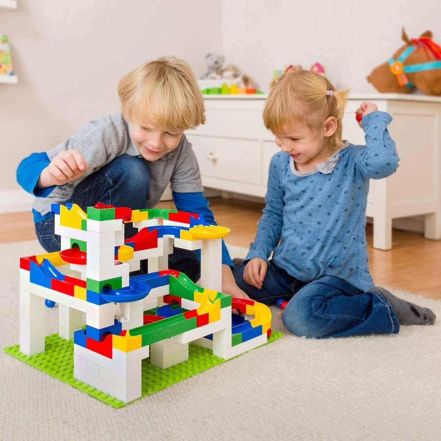 Two children playing with HABA USA Hubelino Big Building Box Set in a room.