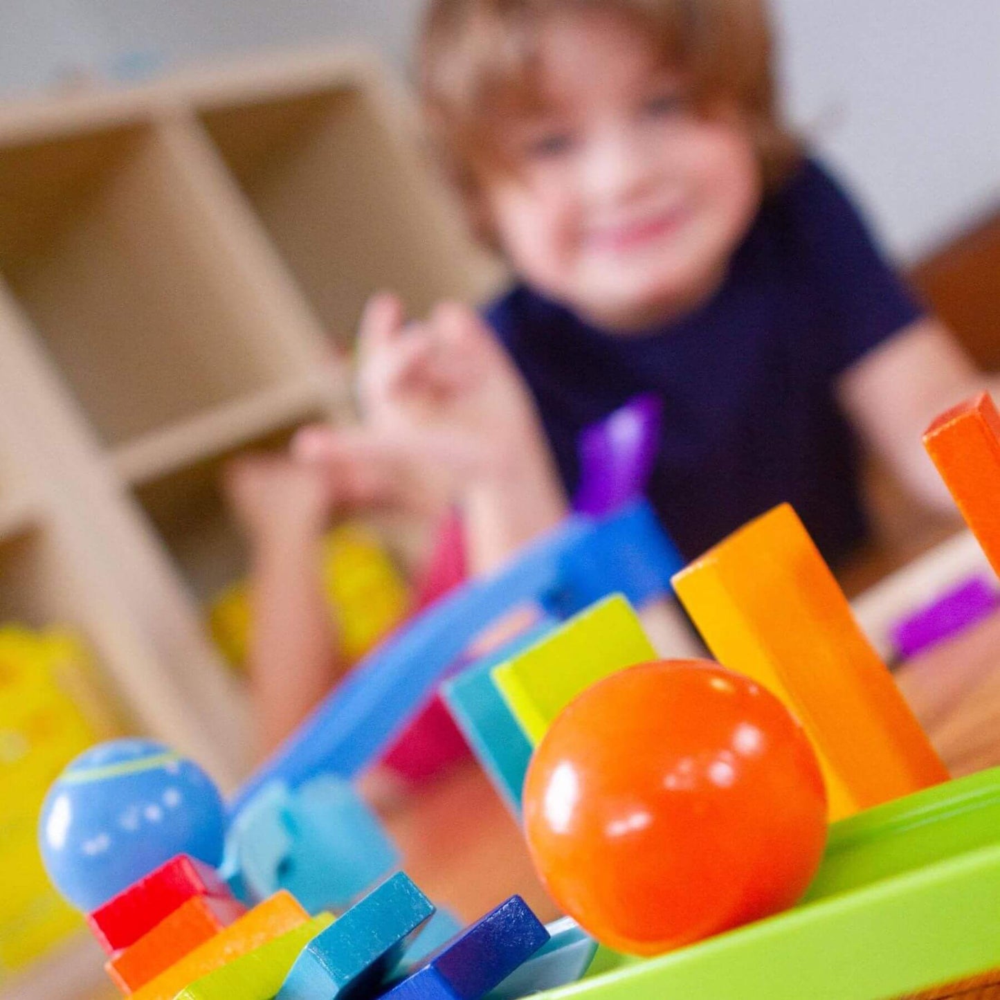Colorful toy blocks with a child in the background
