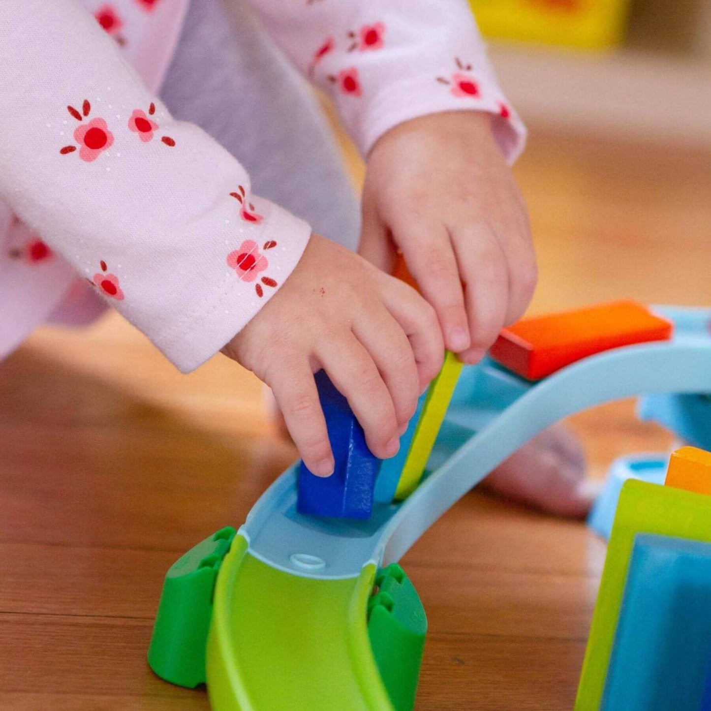 Child's hands playing with HABA USA Kullerbu Kringel Domino Play Track Starter Set