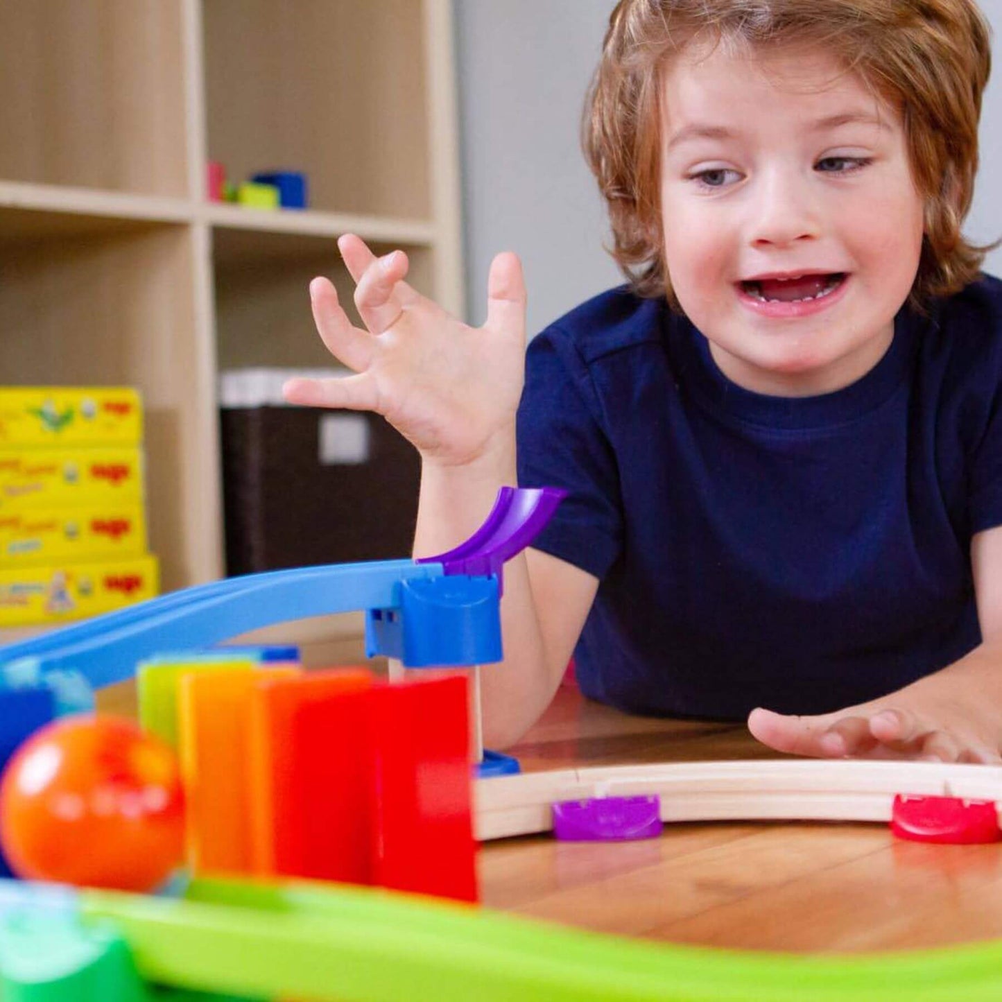Child playing with HABA USA Kullerbu Kringel Domino Play Track Starter Set on a table