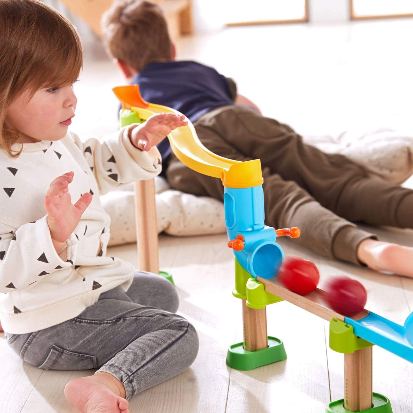 Child playing with HABA USA Kullerbu Traffic Jam Ball Track Set indoors.