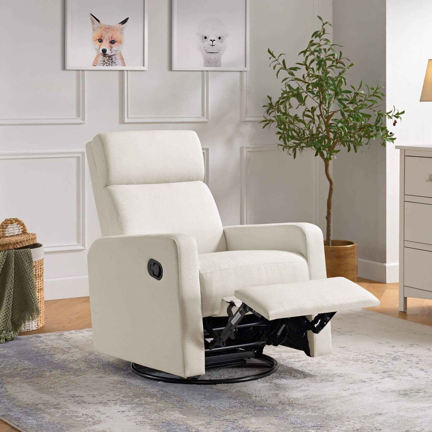 Oxford Baby Layton Glider / Recliner Cream in a room with a plant and framed pictures on the wall.