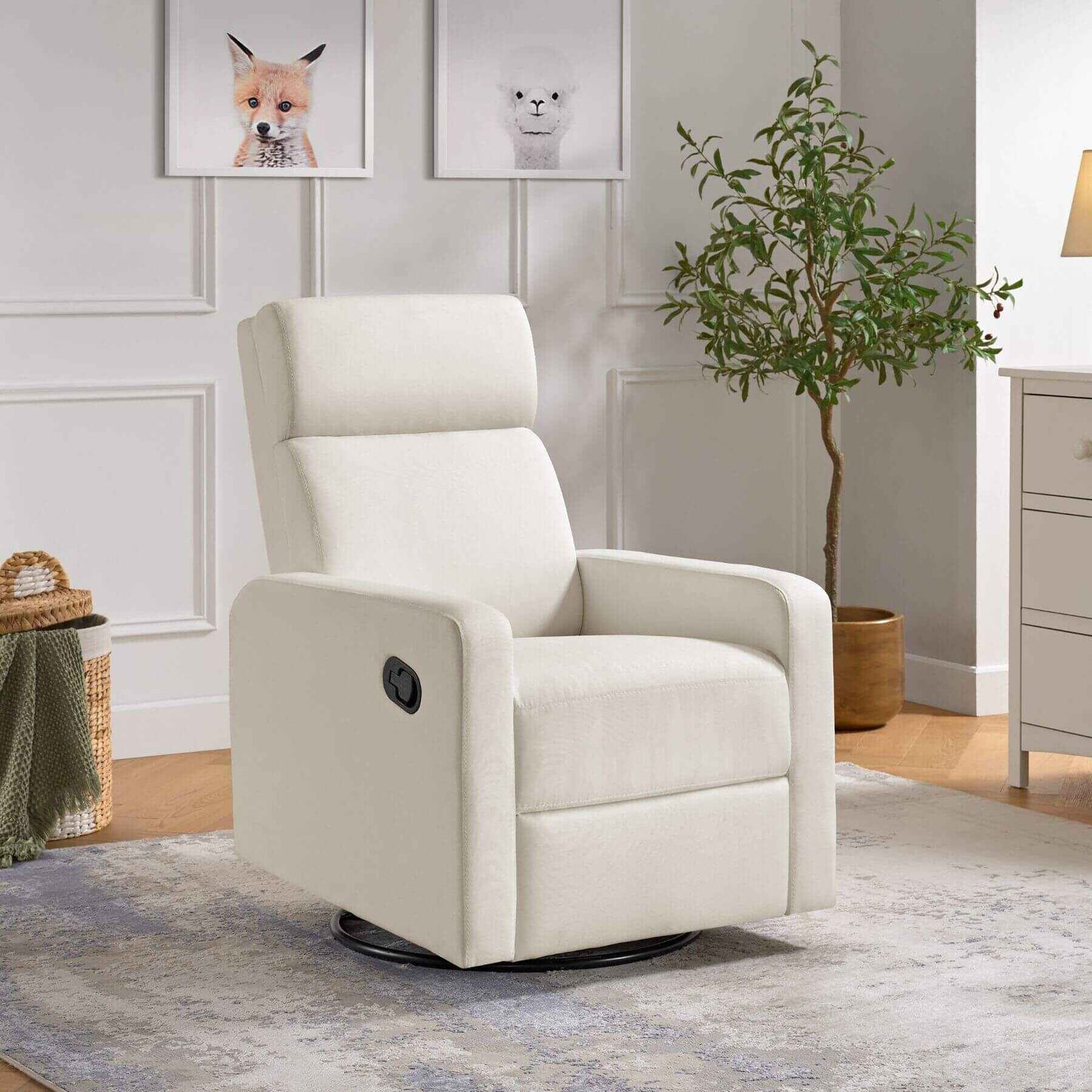 Oxford Baby Layton Glider / Recliner Cream in a living room setting with a plant and framed pictures on the wall.
