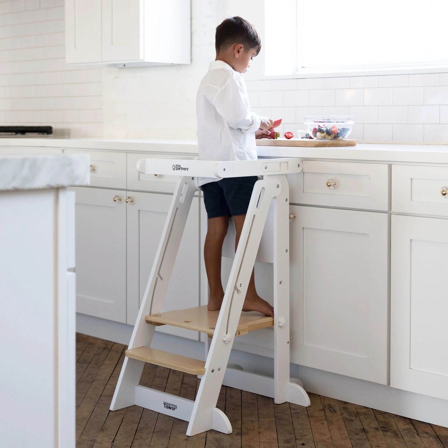 Boy Standing on Little Partners Learn 'N Fold Learning Tower Natural & White
