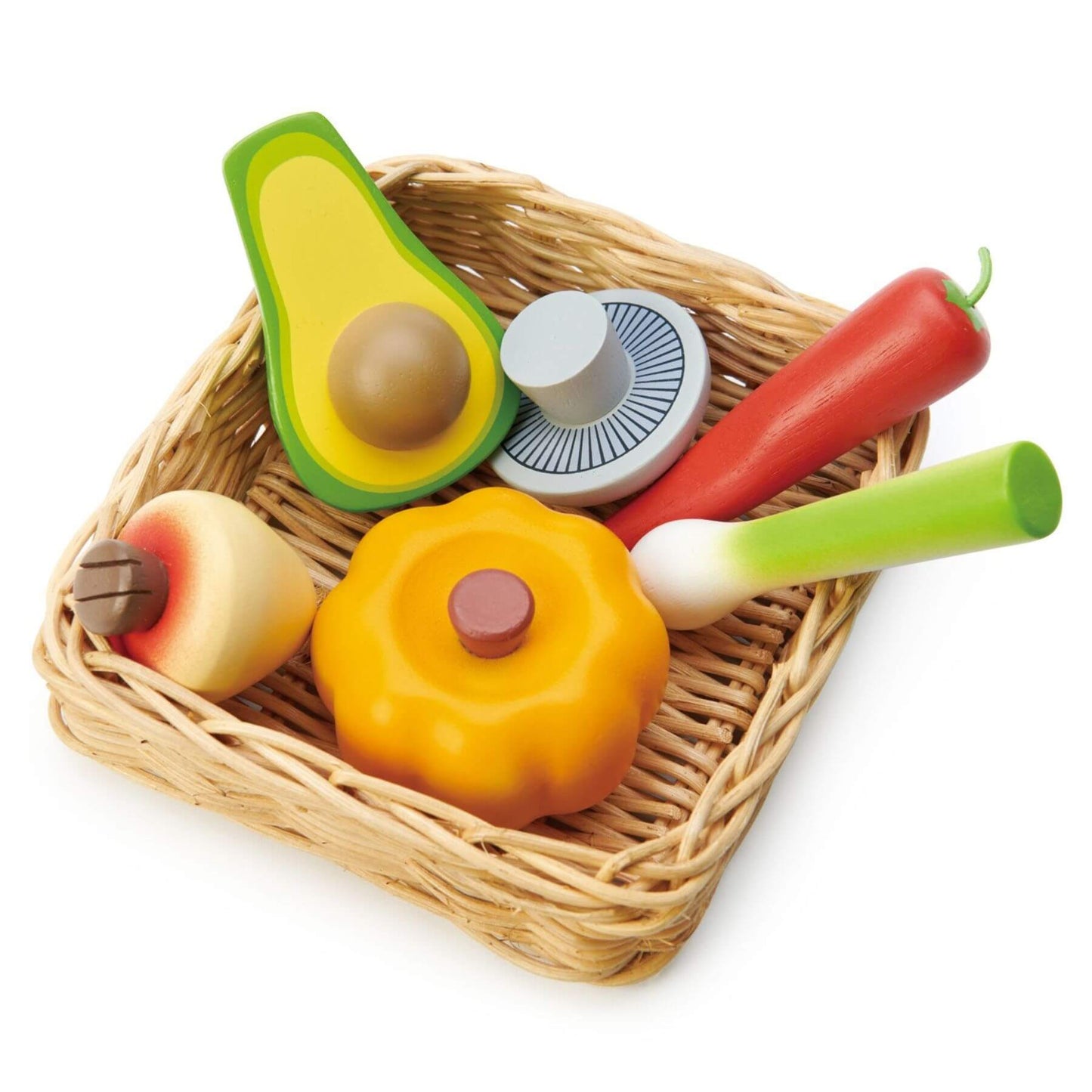 Set of toy vegetables in a wicker basket on a white background