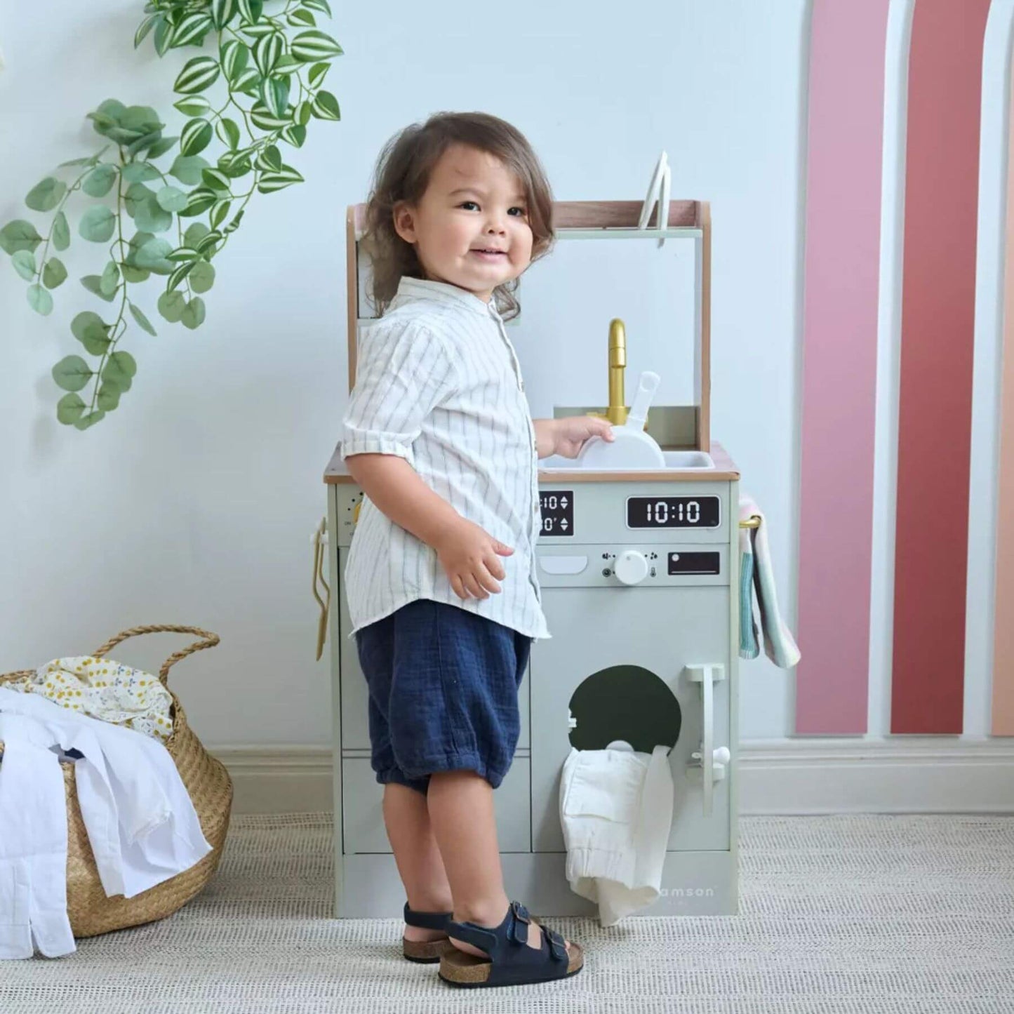 Child standing next to Teamson Kids Little Chef Lake Tahoe Wooden Play Kitchen Green