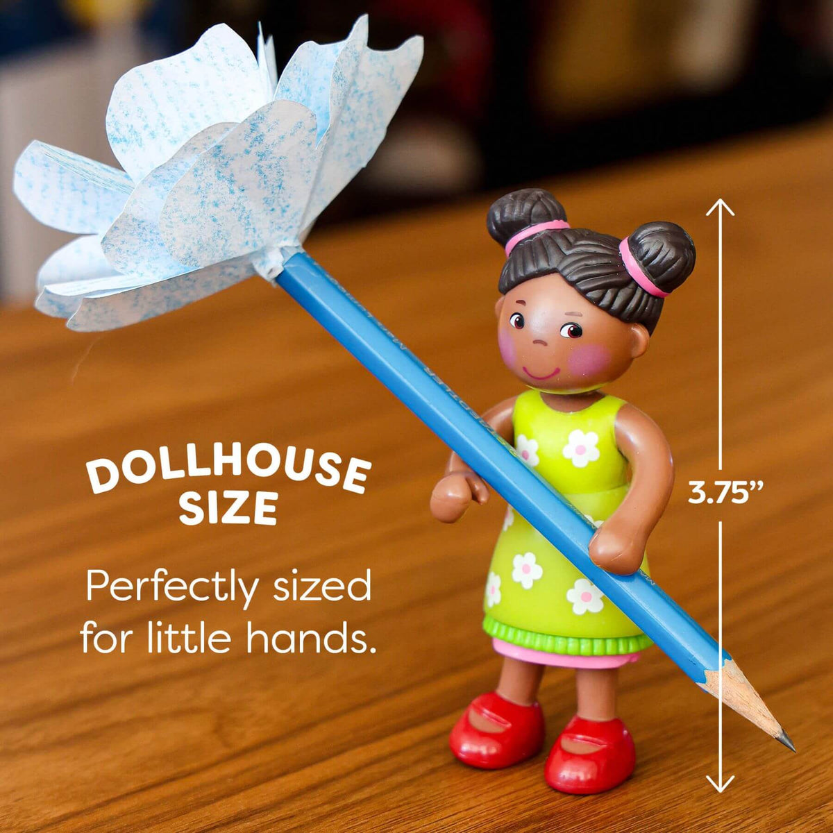 Small figurine holding a pencil with measurement details on a wooden surface