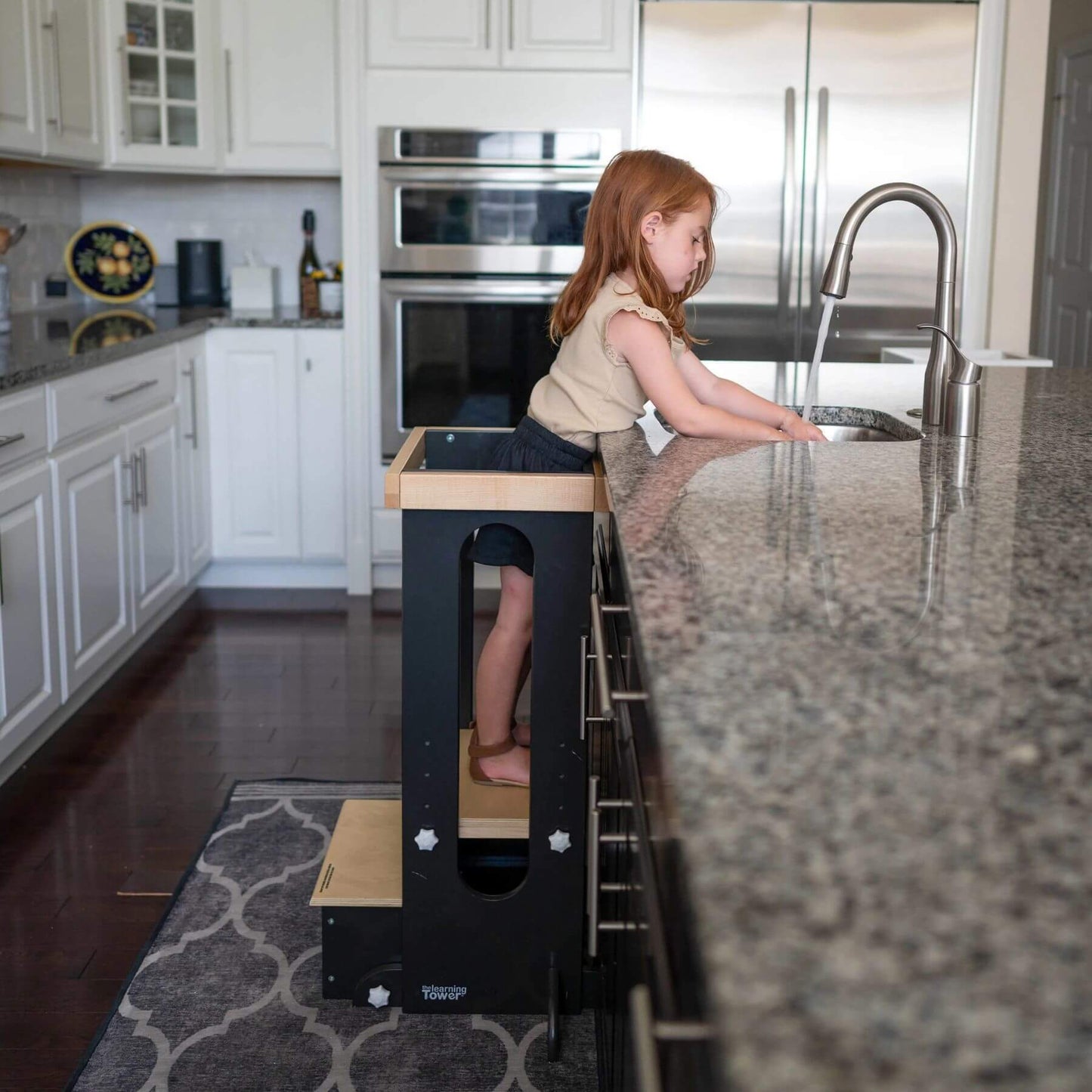 Girl Standing on Little Partners Explore 'N Store Learning Tower Charcoal & Natural, Washing Hands at Kitchen Sink