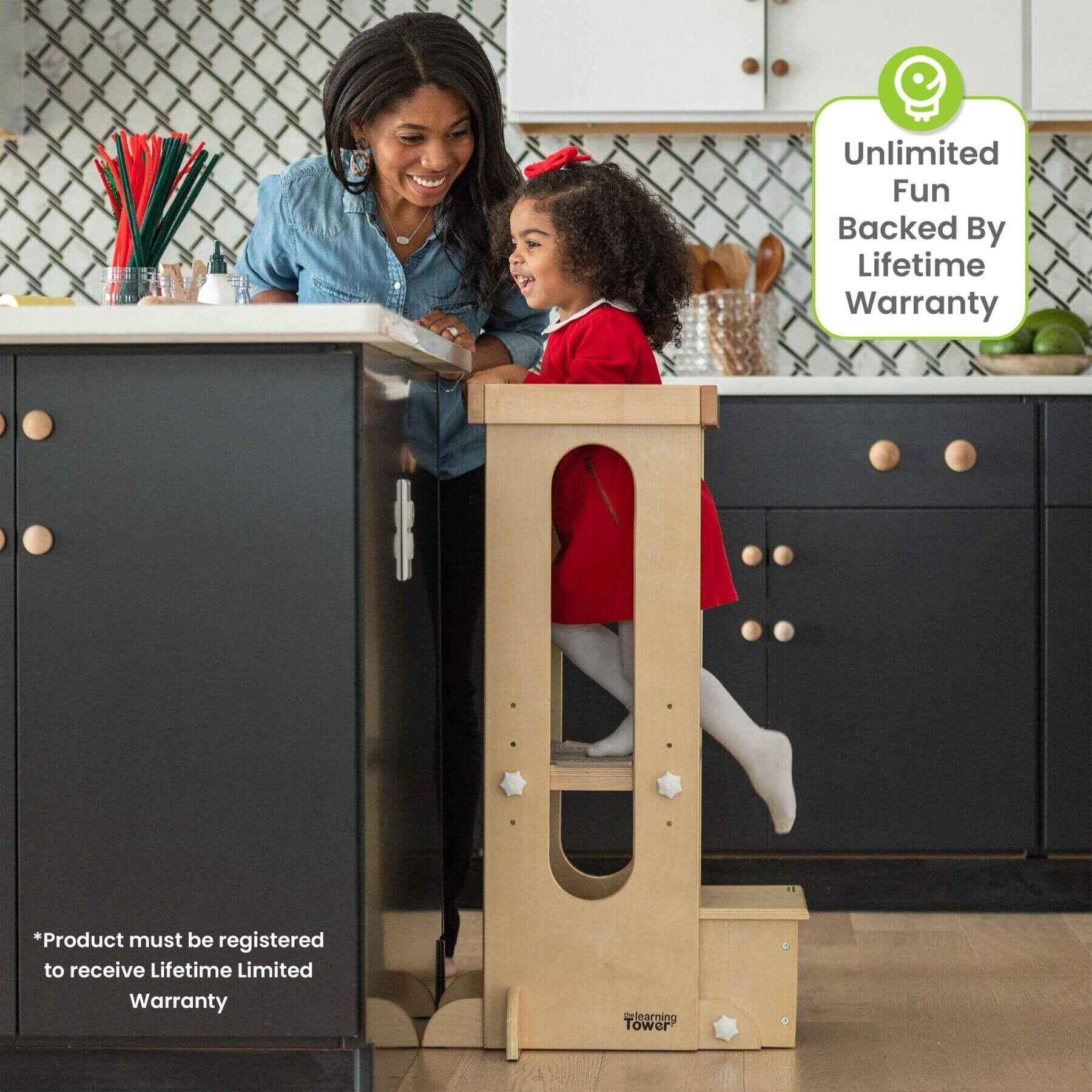 Girl Standing on Little Partners Explore 'N Store Learning Tower Natural next to Mom