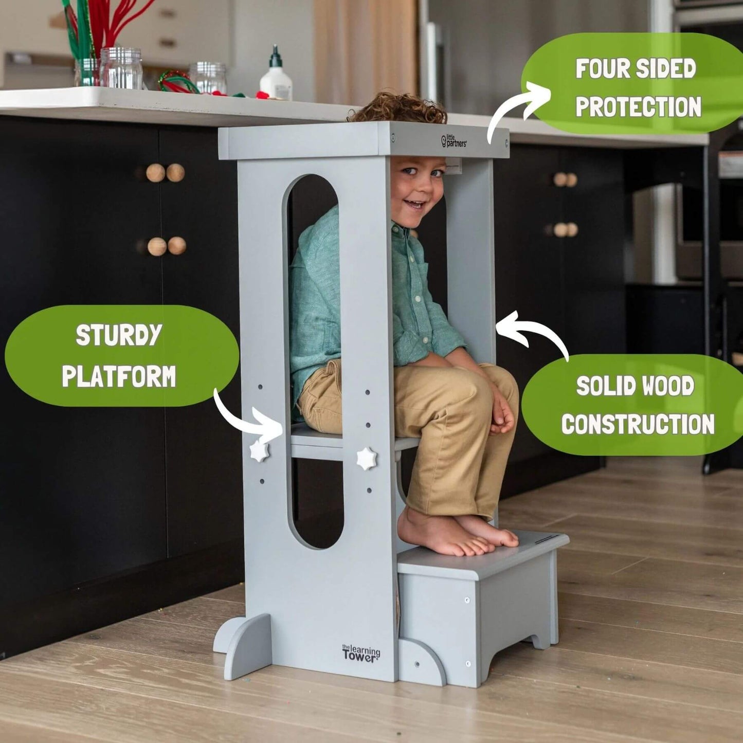 Boy Sitting on the platform of Little Partners Explore 'N Store Learning Tower Silver