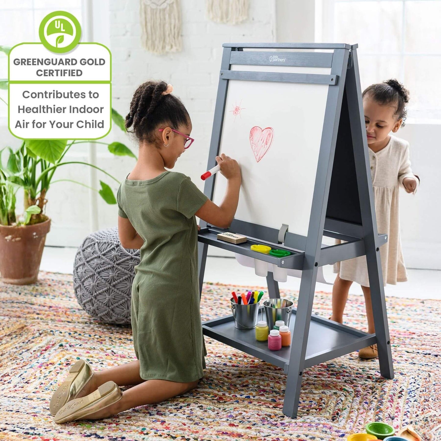 Two children using a Little Partners Folding Artist EZ Easel Grey in a home setting.