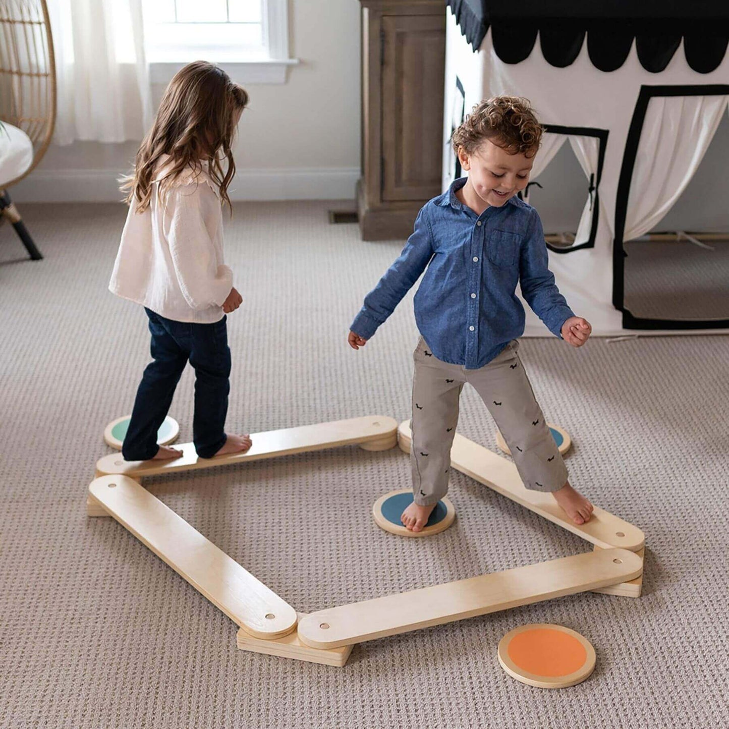 Two children playing with Little Partners Learn 'N Balance Set in a room.