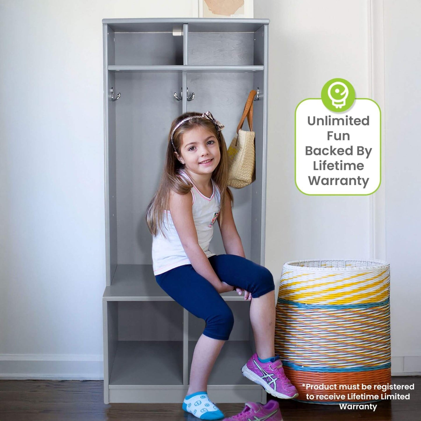 Child sitting on Little Partners Learn 'N Store Cubby Grey with a basket and bag, and a warranty badge in the corner.
