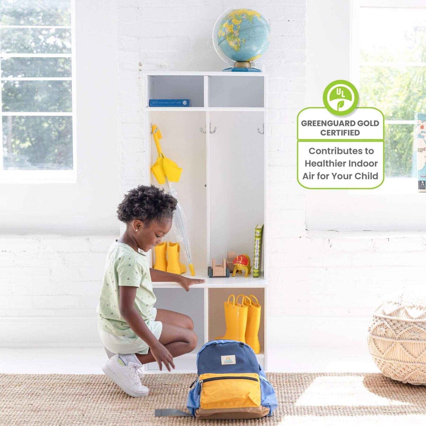 Child organizing items in Little Partners Learn 'N Store Cubby with a blue backpack on the floor.