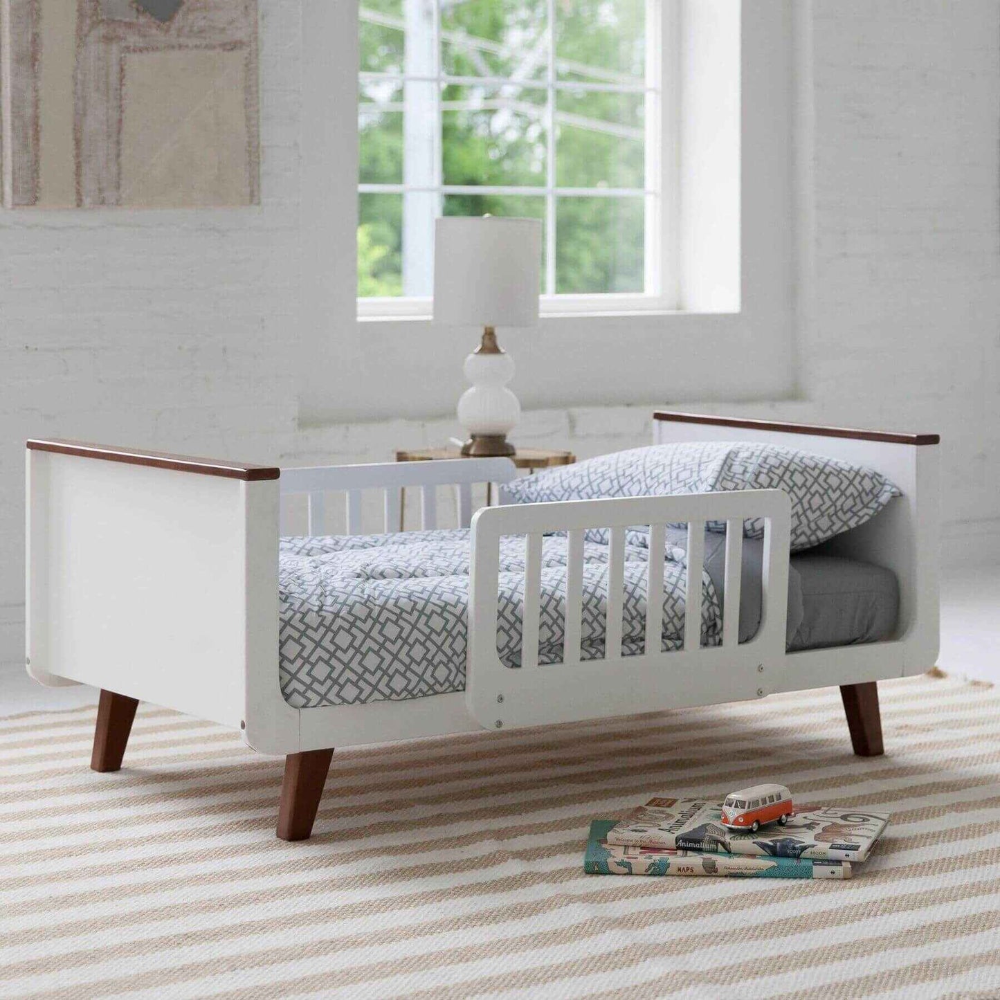 Little Partners MOD Toddler Bed Espresso & White in a bright room with large windows.
