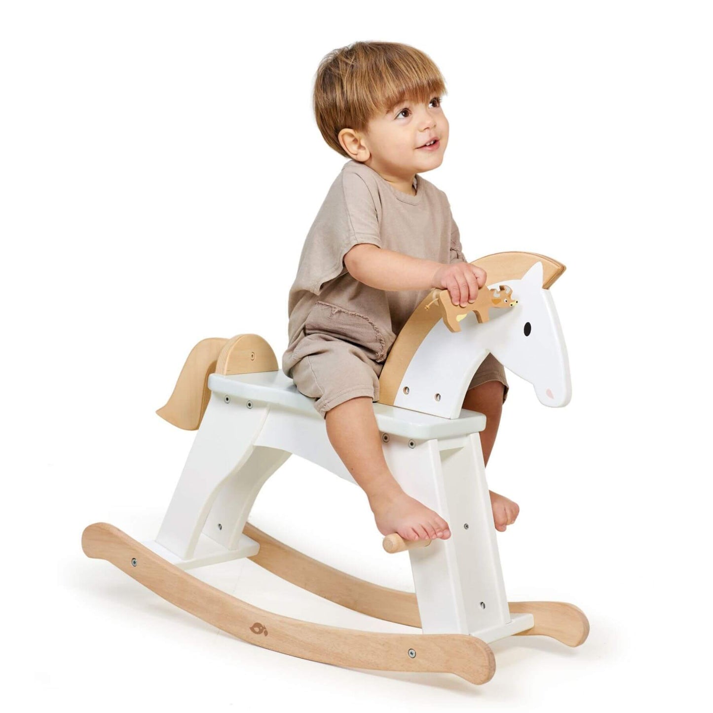 Child sitting on Tender Leaf Lucky Rocking Horse against a white background