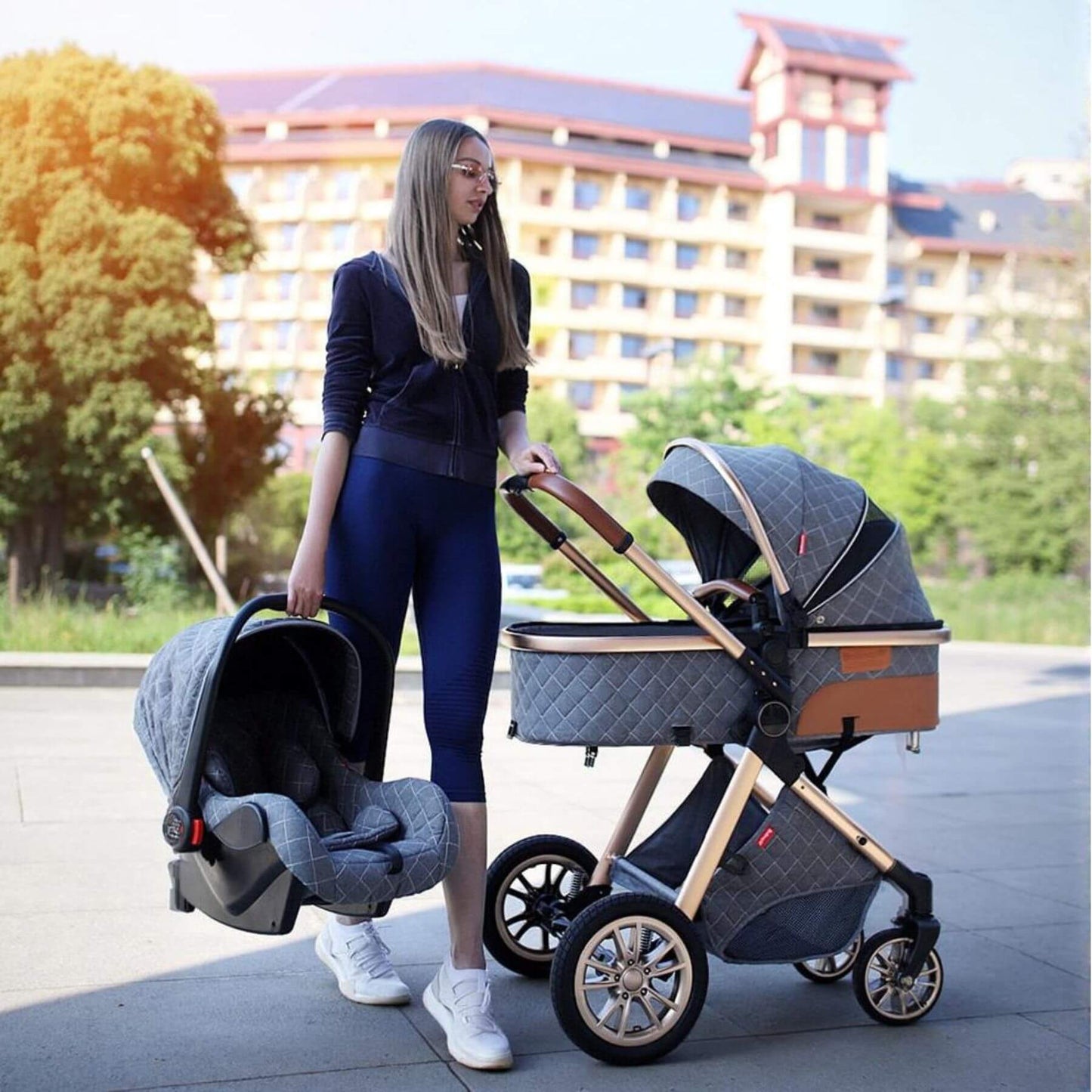 Woman pushing a stroller with a car seat attached outdoors.