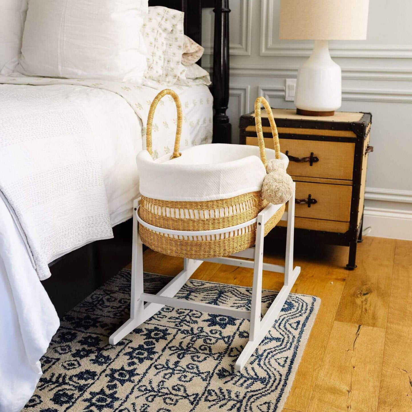 Modern Open Weave African Moses Basket Vegan Handle on a stand in a bedroom setting with a bed and nightstand.