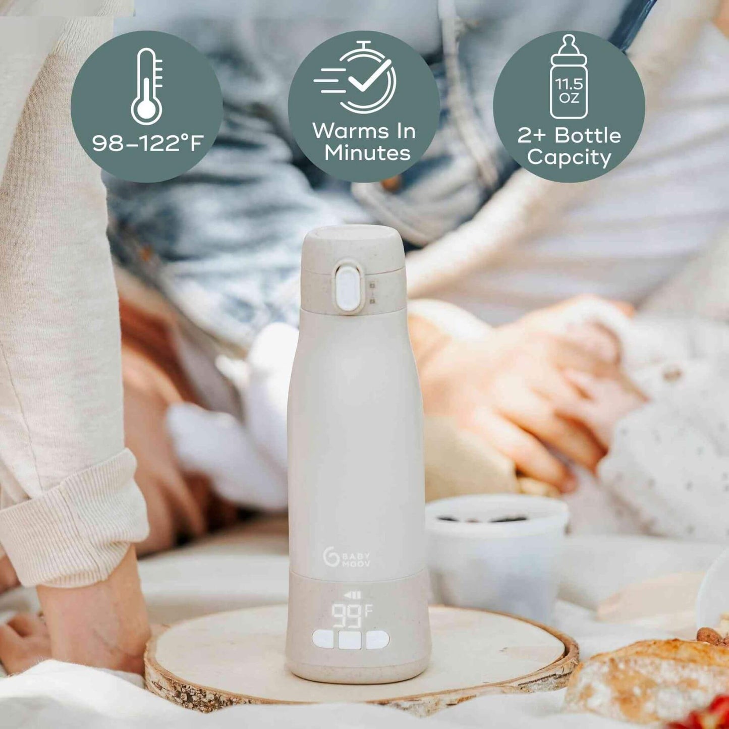 Moov & Feed Portable Milk and Water Warmer on a wooden coaster with text indicating temperature, warming time, and capacity.