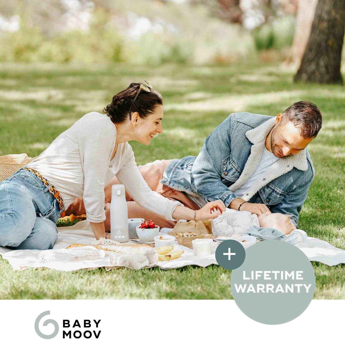 Couple having a picnic in a park with Moov & Feed Portable Milk and Water Warmer and food