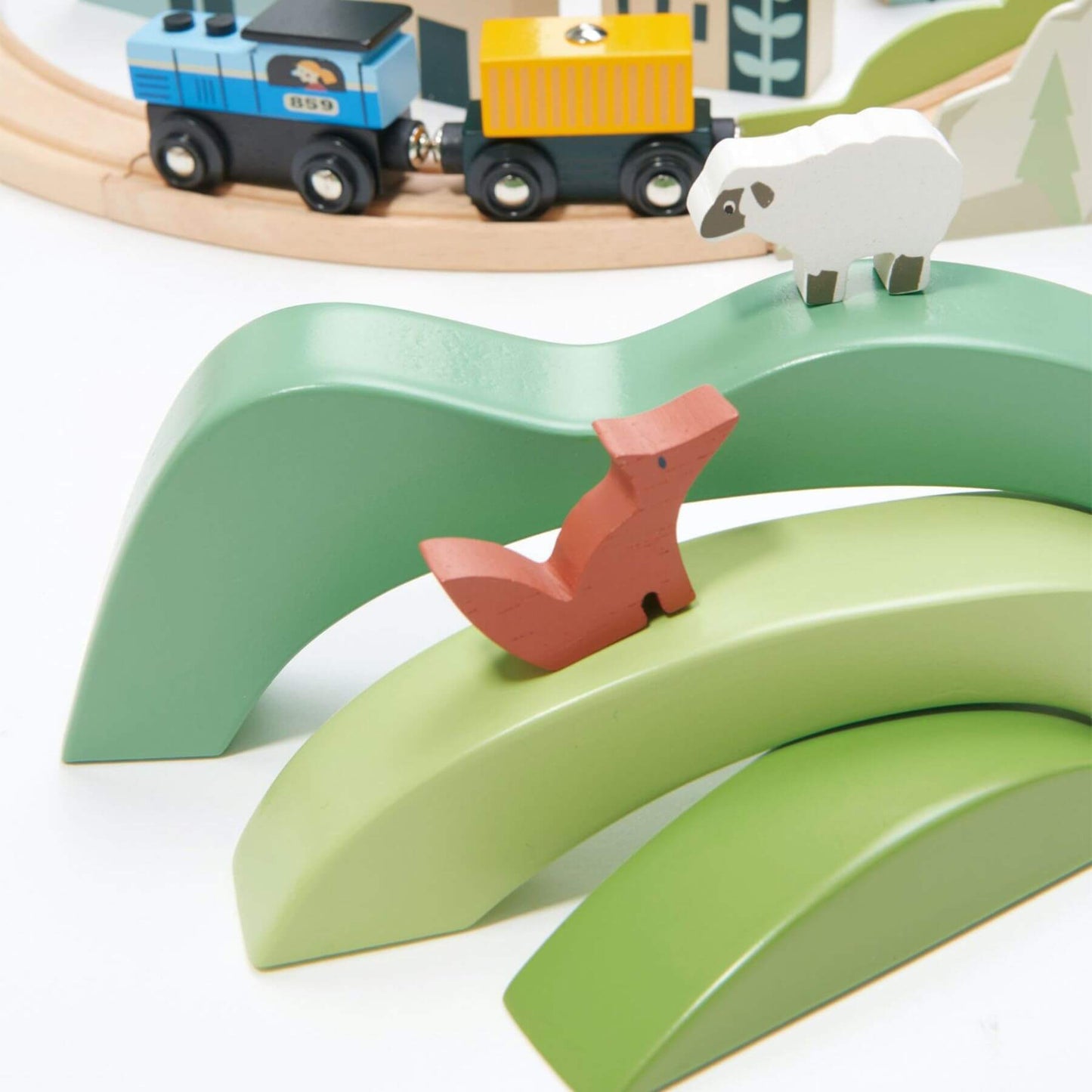 Wooden toy train set with tracks and animals on a white background