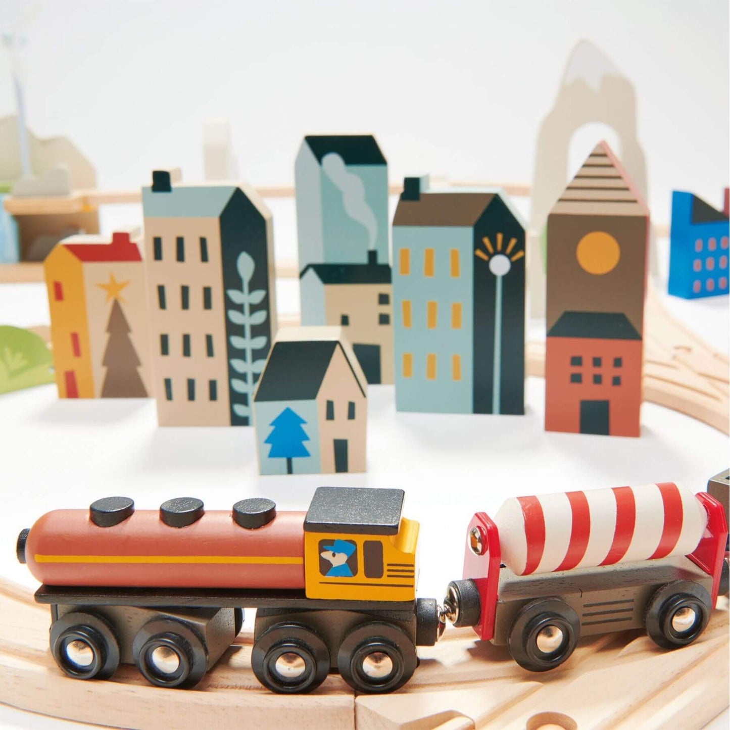 Wooden toy train set with colorful buildings in the background
