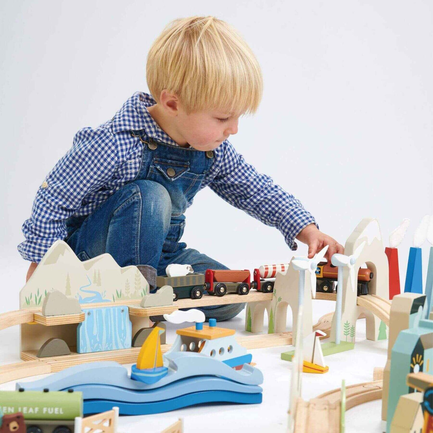 Child playing with Tender Leaf Mountain View Train Set on a white background