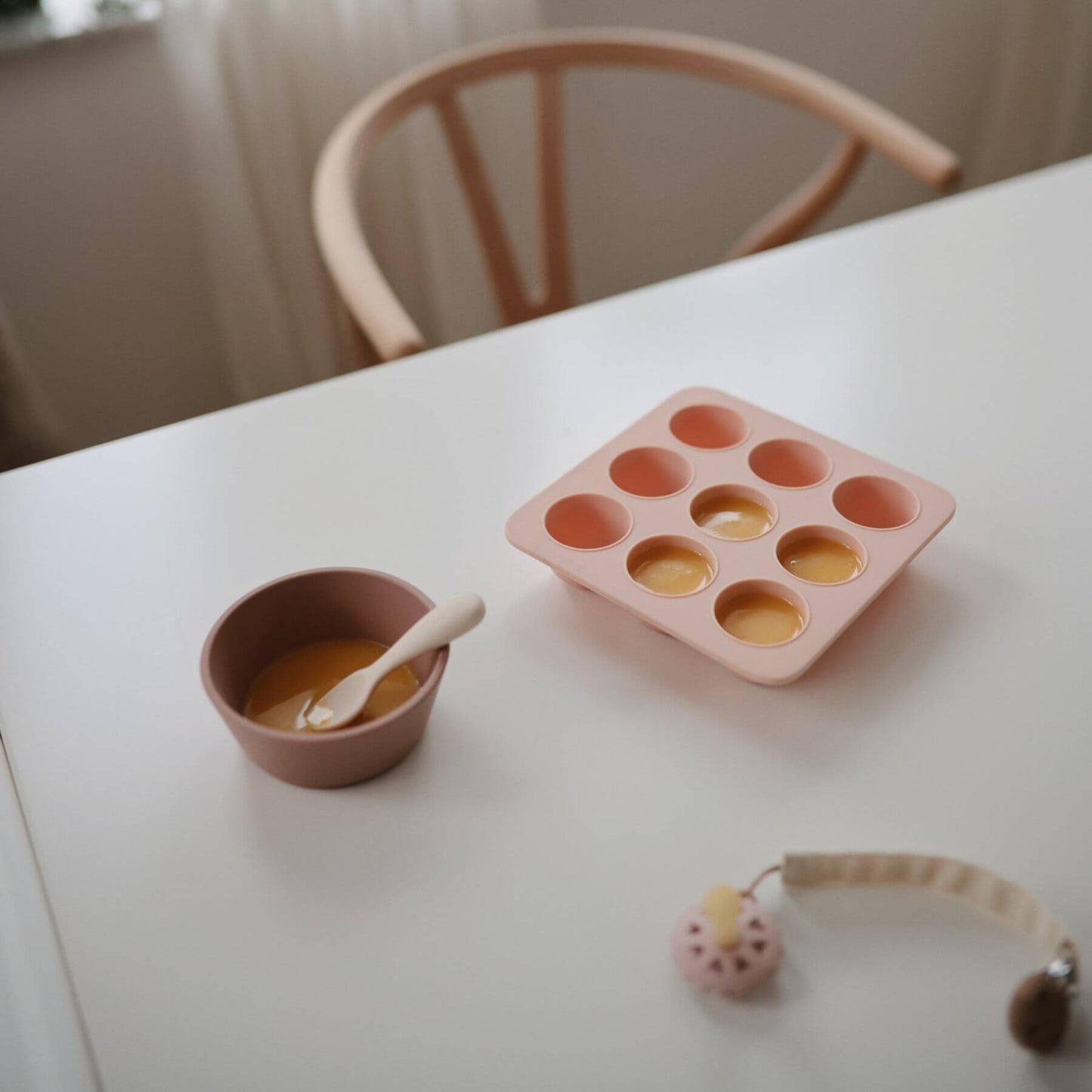 Mushie Baby Food Freezer Tray with small cups on a white table