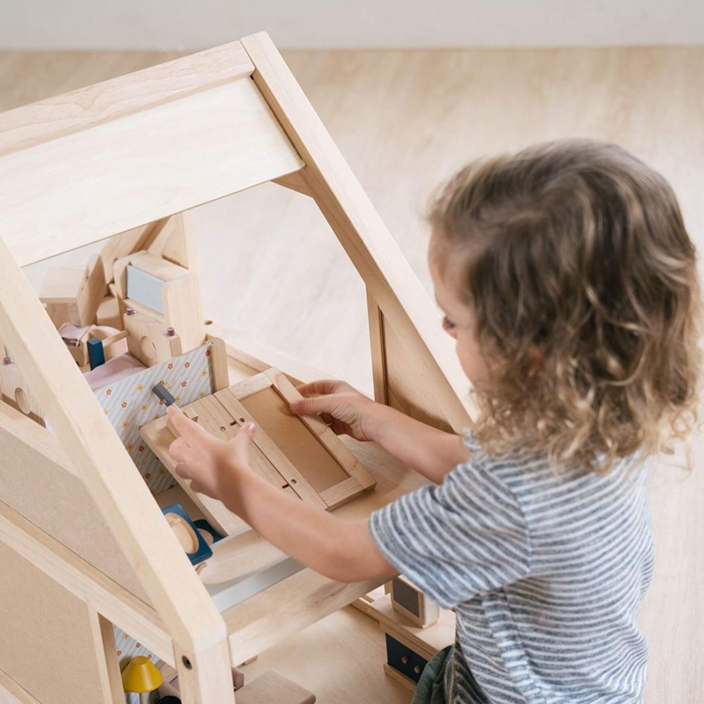Child playing with PlanToys My First Dollhouse