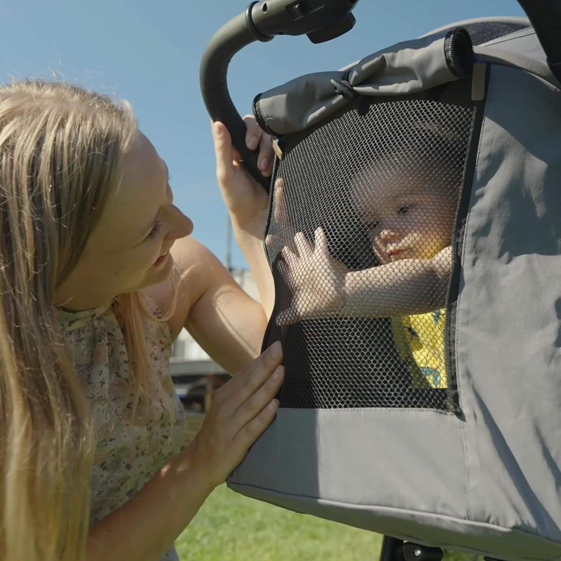 Woman interacting with a baby in a stroller seat