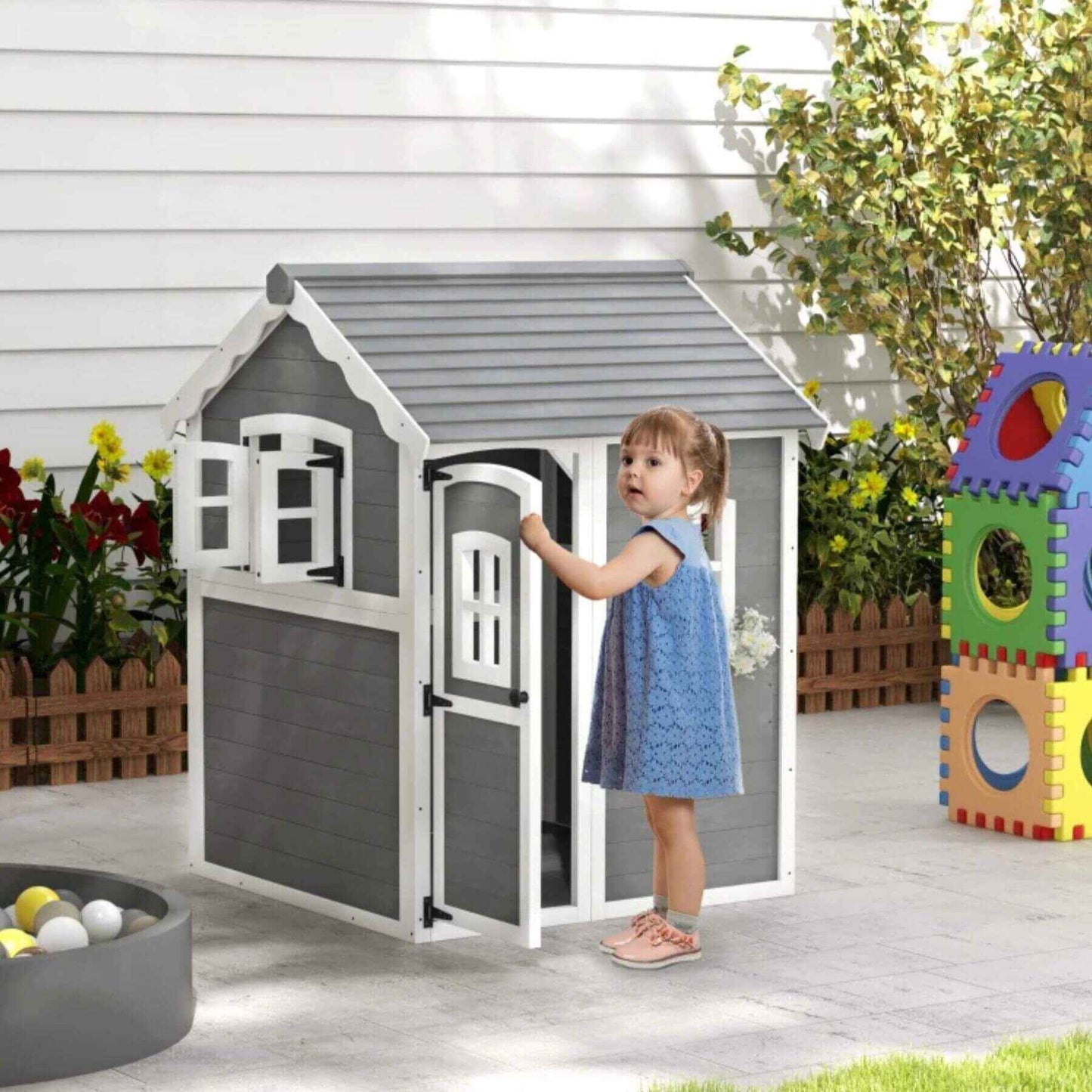 Girl Holding the Door of Outsunny Outdoor Wooden Playhouse for Kids Gray