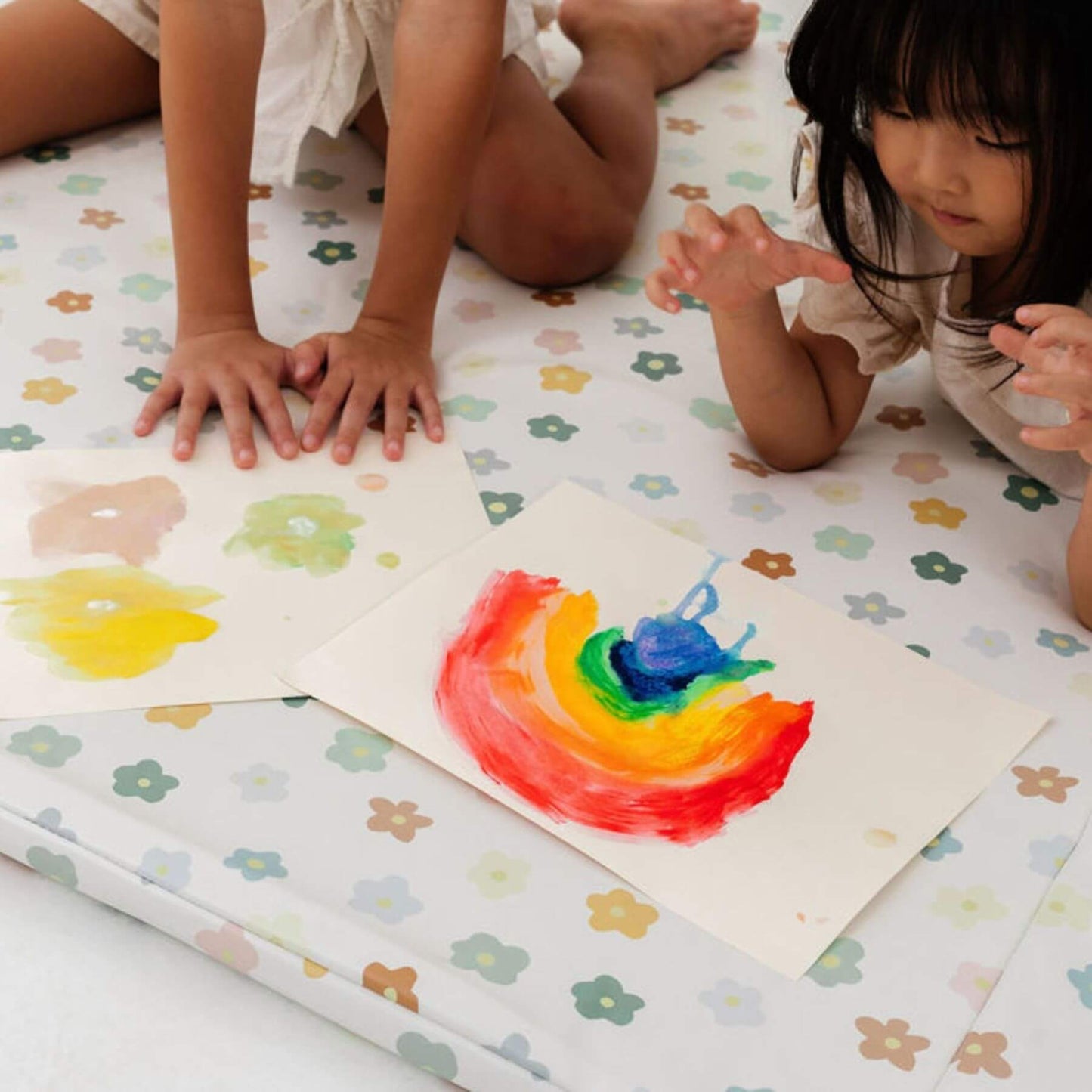 Two children playing with colorful art on Toki Kids Playful Posies Vegan Leather Mat