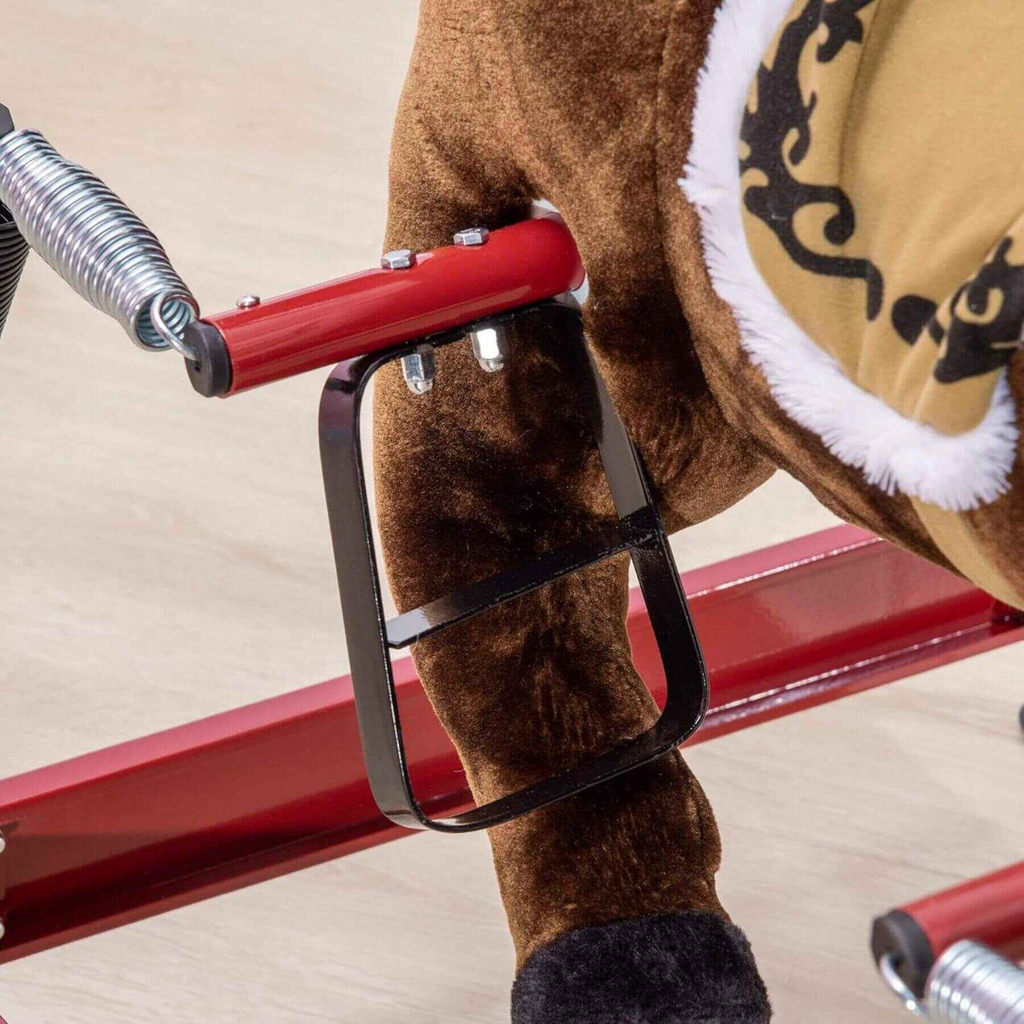 Close-up of a brown plush toy horse with a red handle on a beige background