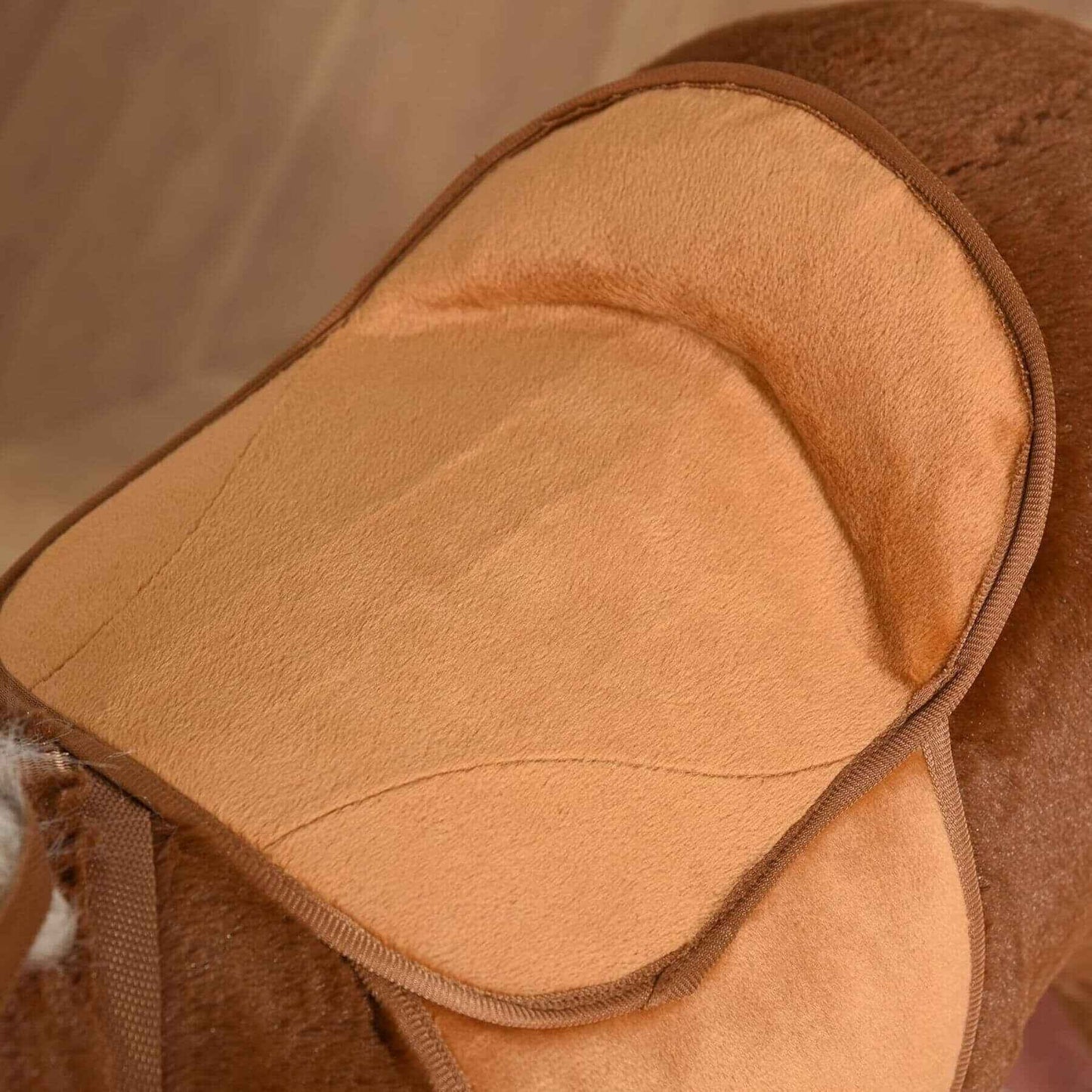 Close-up of a brown leather saddle pad with a soft interior.