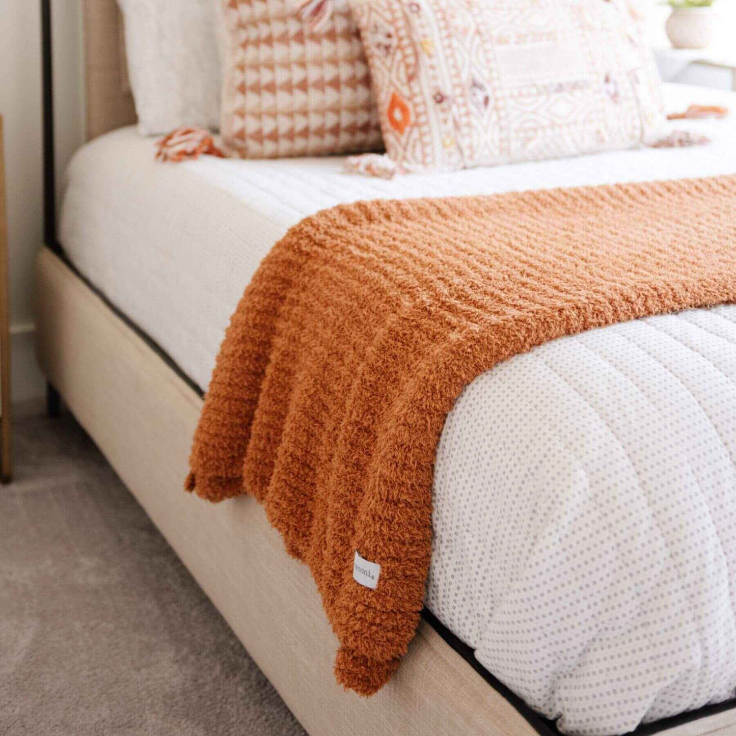 Beige bed with Ribbed Bamboni® Throw Blankets Ginger and white pillows