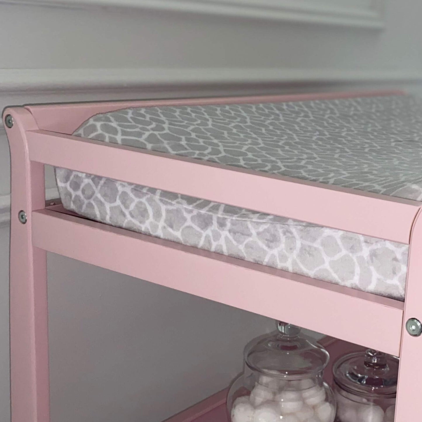 Riley Changing Table Pink with a gray patterned cushion on a white background