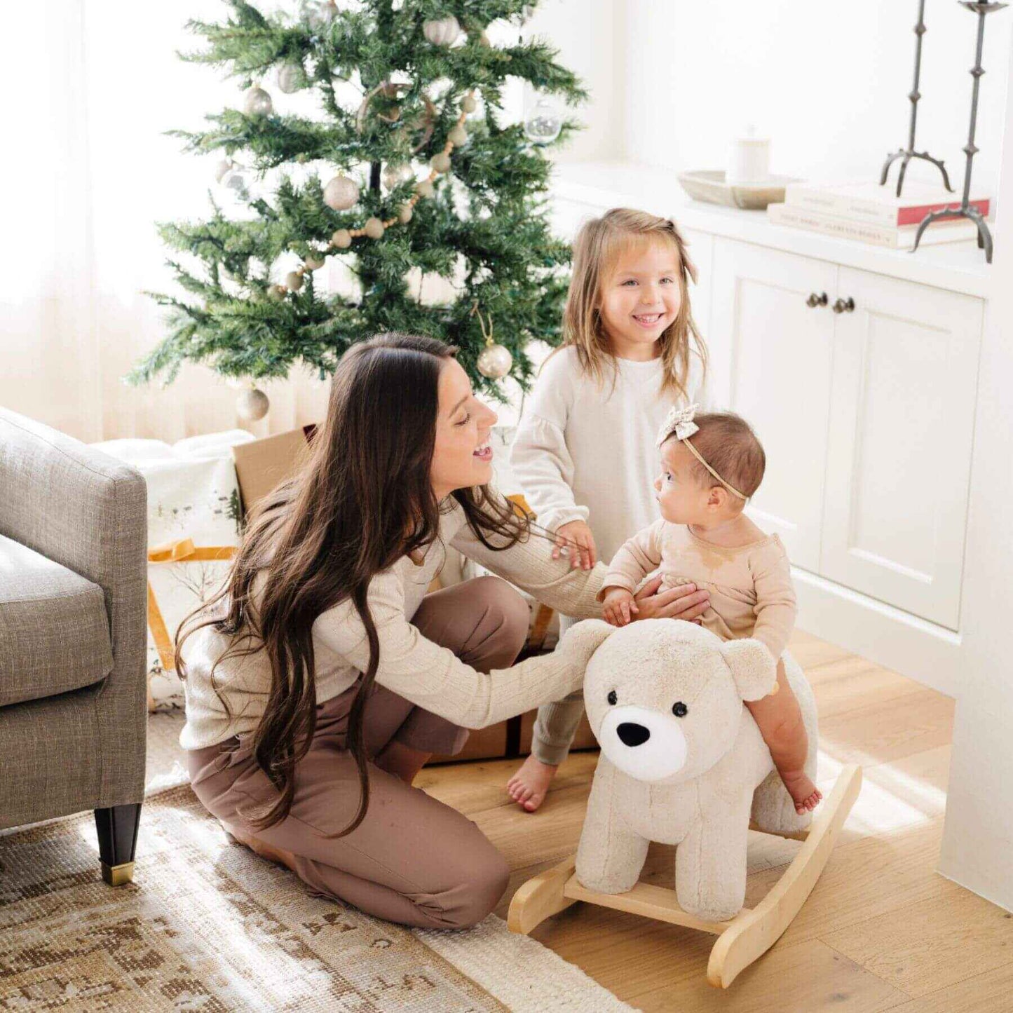 Woman and two children with Saranoni Stuffed Animal Rocker - Bear in a home setting with a Christmas tree.