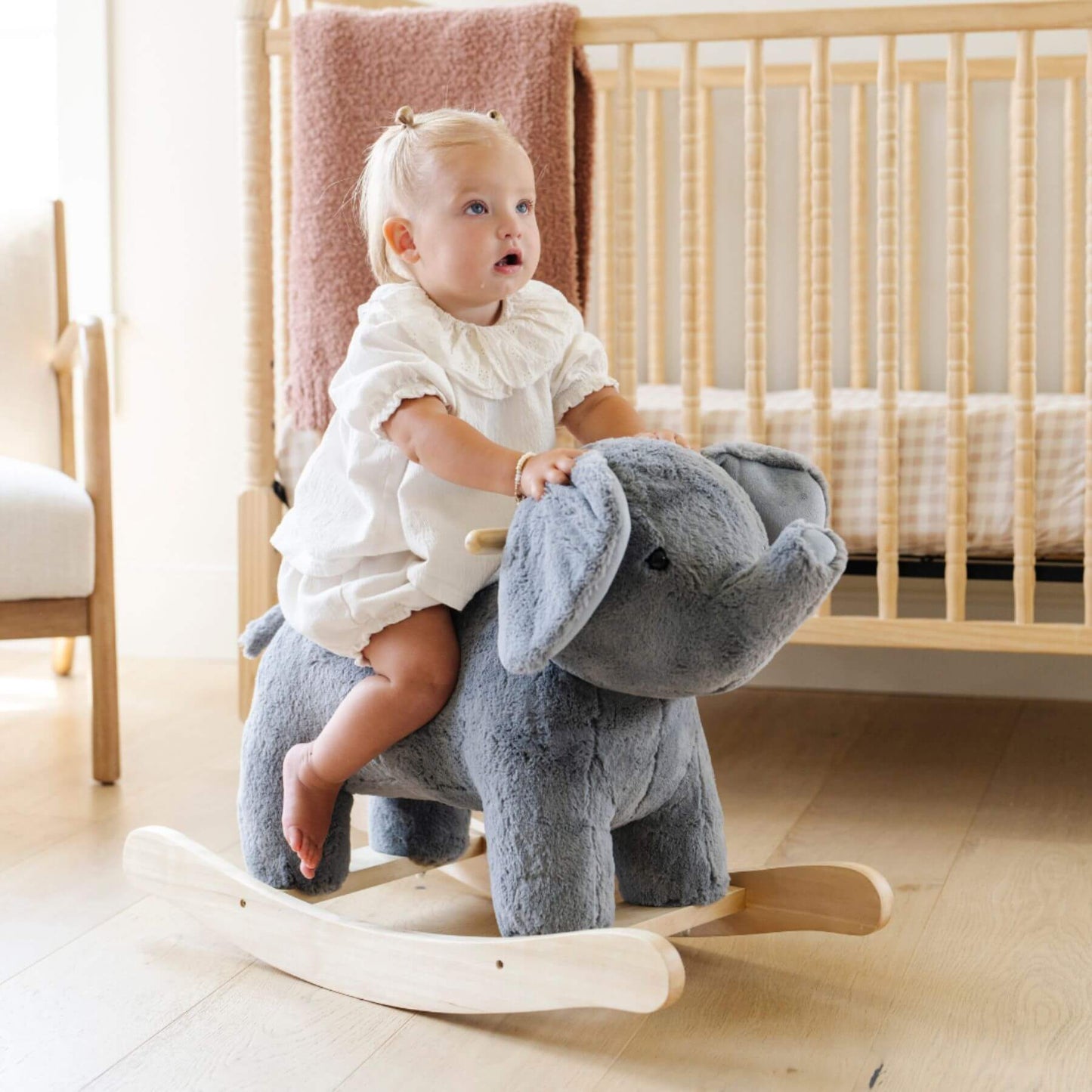 Child sitting on Saranoni Stuffed Animal Rocker - Elephant in a nursery.