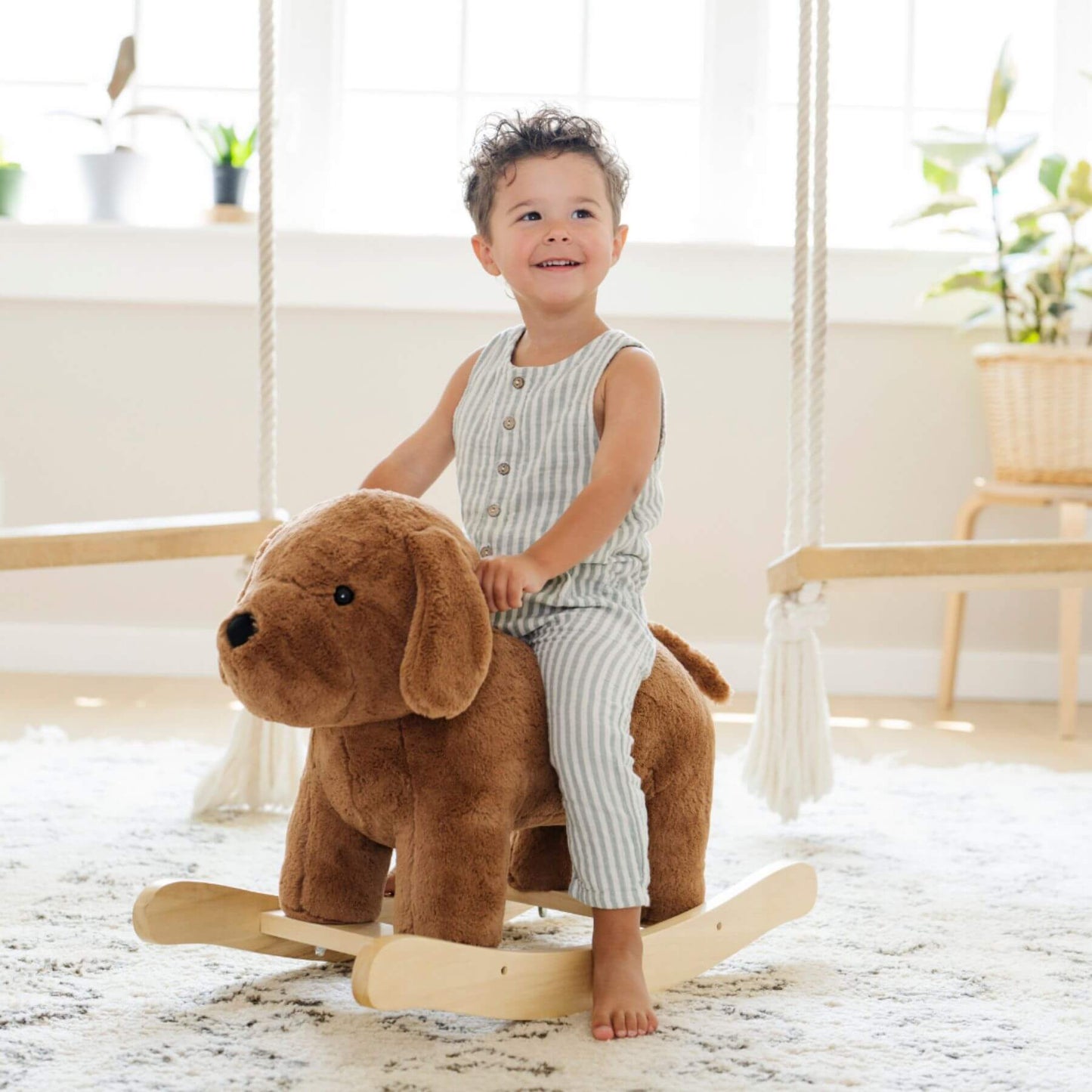 Child sitting on a Saranoni Stuffed Animal Rocker - Dog indoors.