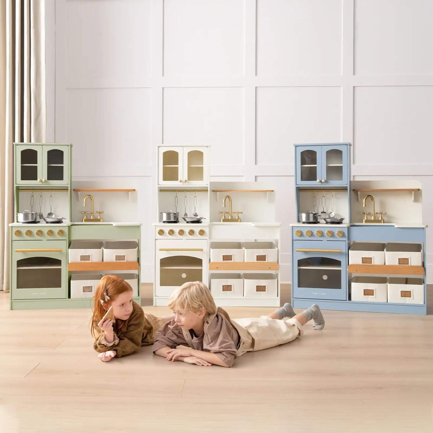 Tiny Land® Serenity Play Kitchen Sage Green in a room with white paneled walls.