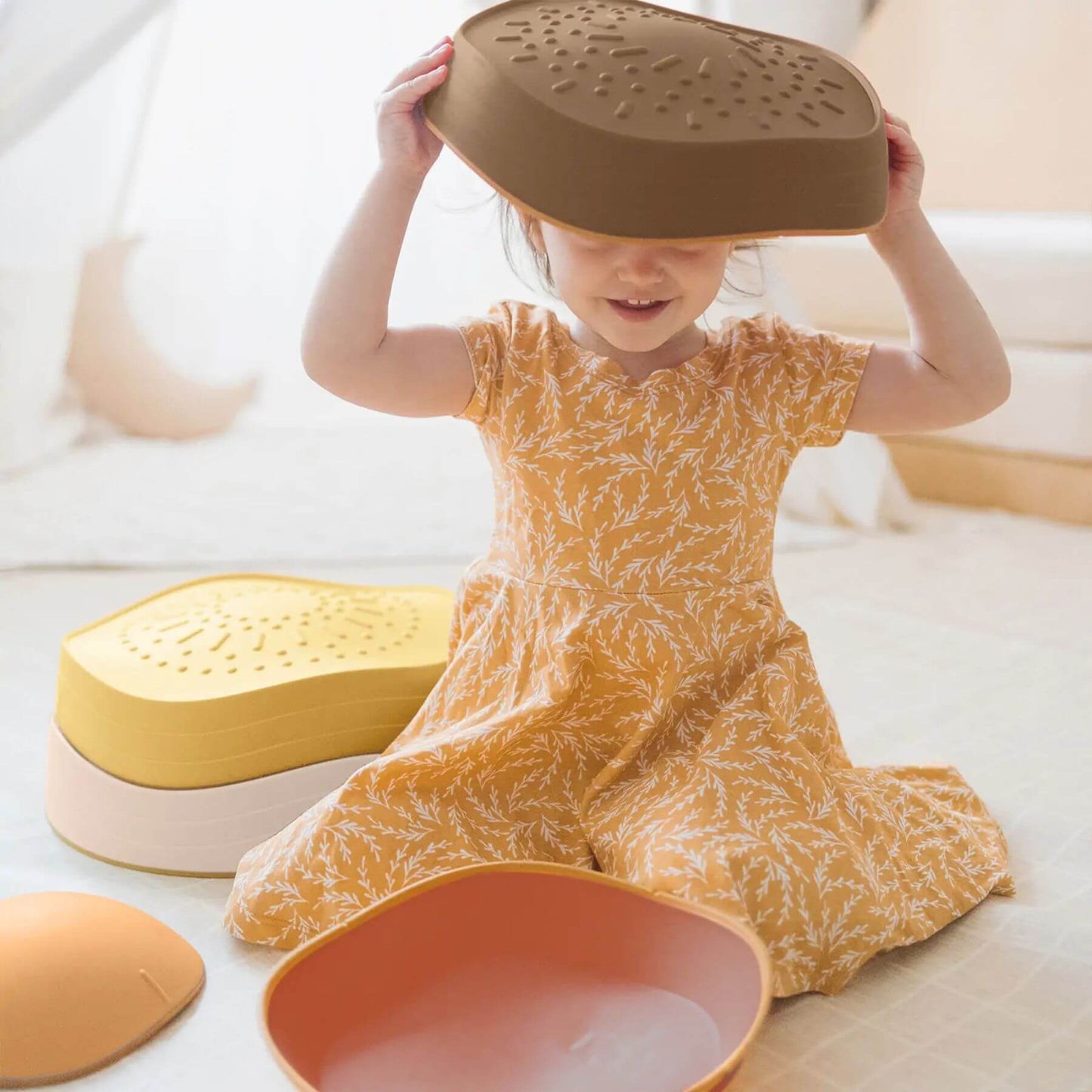 Child playing with Tiny Land® Stepping Stones - Sunset Hues on a light background