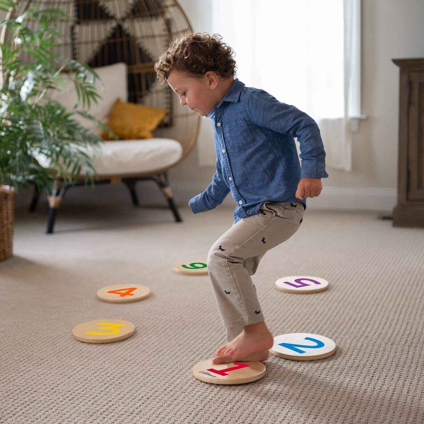 Child playing with Little Partners Step 'N Learn Stepping Stones on a carpeted floor