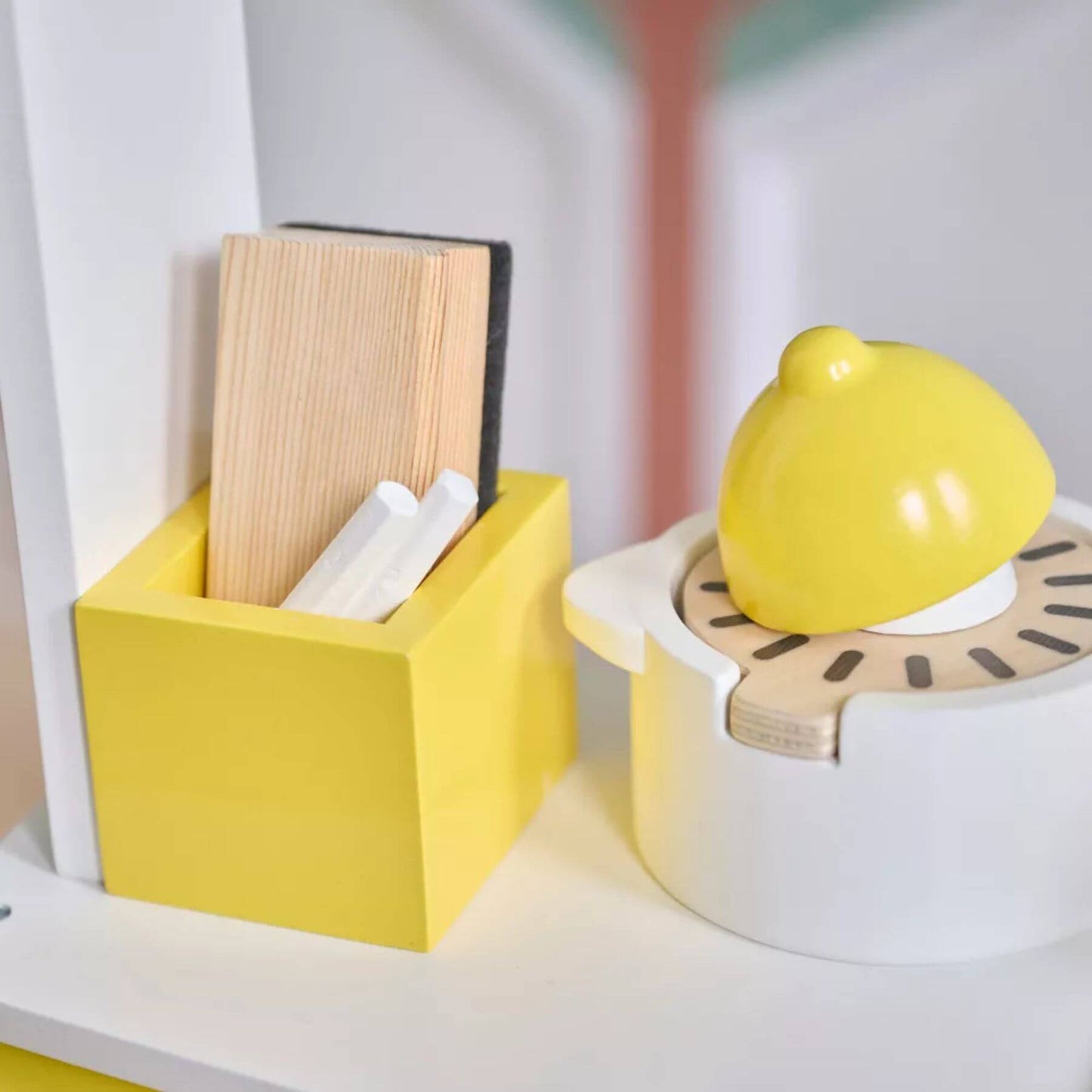 Yellow container with books and a white container with a lemon-shaped object on a shelf.