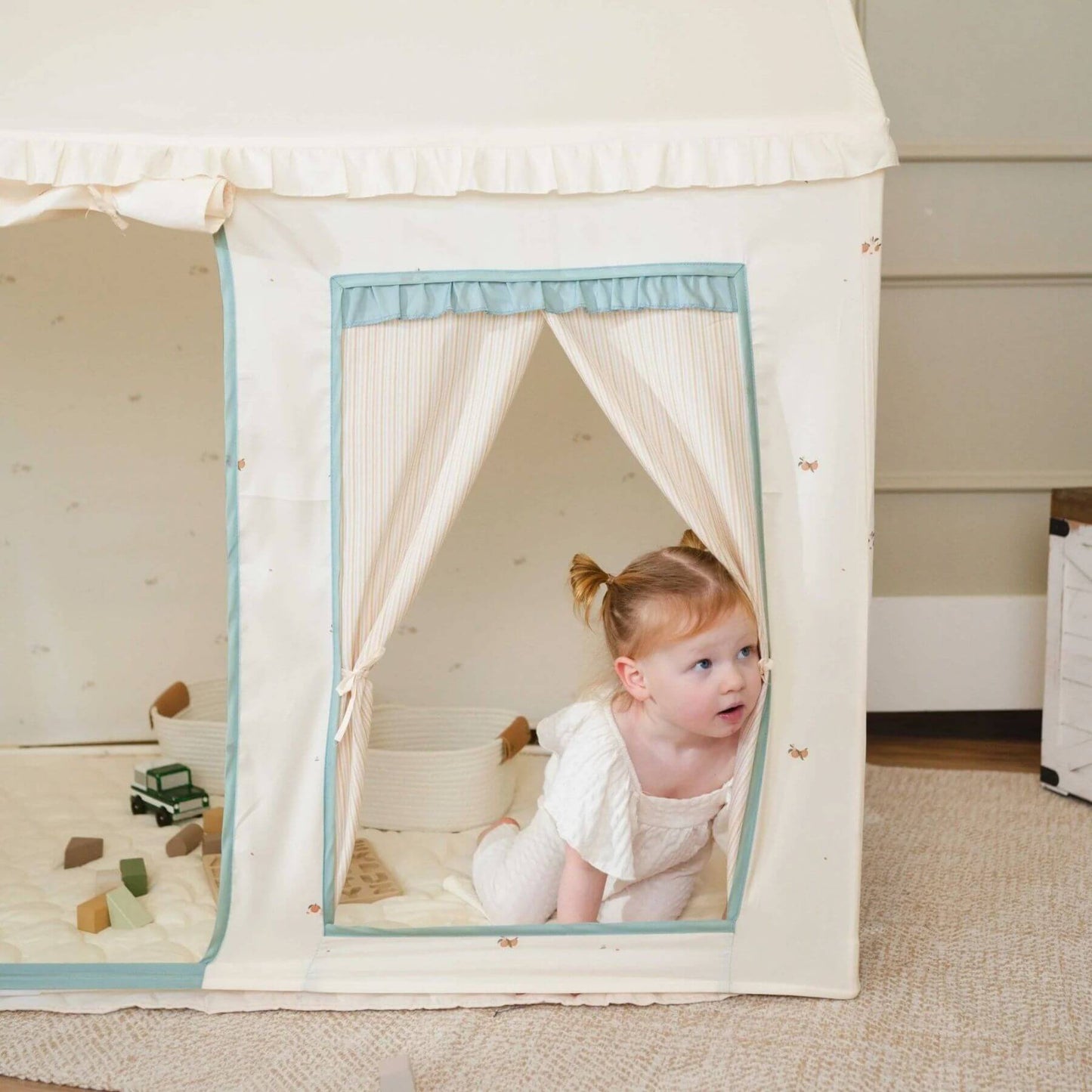 Child peeking out from Tiny Land® Sweet Citrus Kid's Play Tent - Creamy white/blue on the floor.