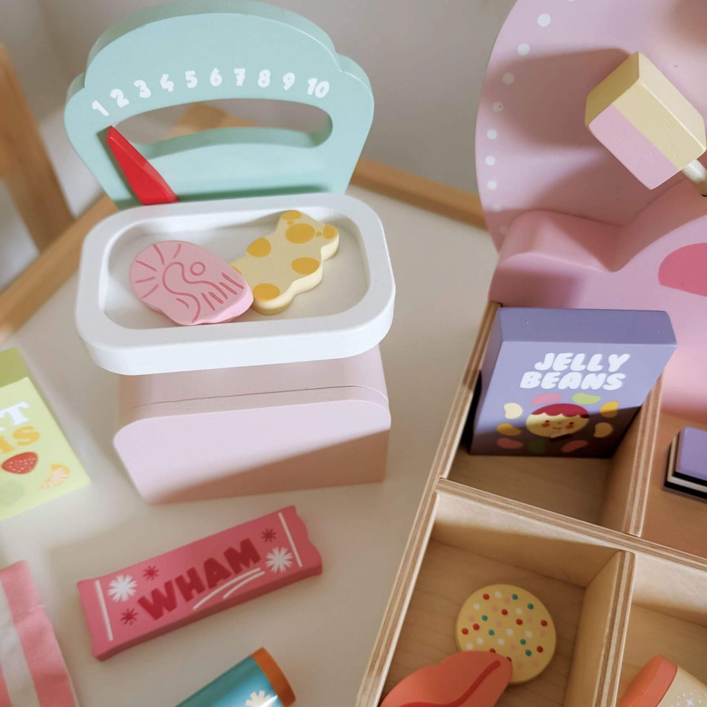 Colorful toy kitchen set with a container labeled 'Jelly Beans' on a wooden surface.