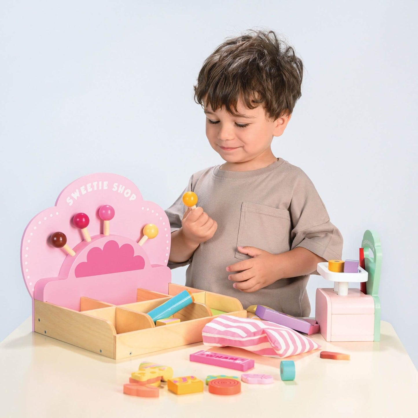 Child playing with Tender Leaf Sweetie Pic'n'Mix Shop on a light blue background