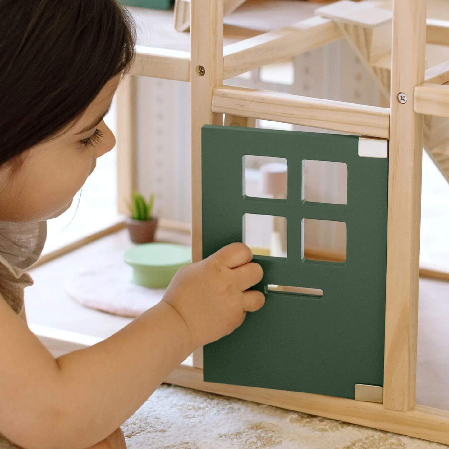 Child playing with Sweetwood Evergreen Dollhouse